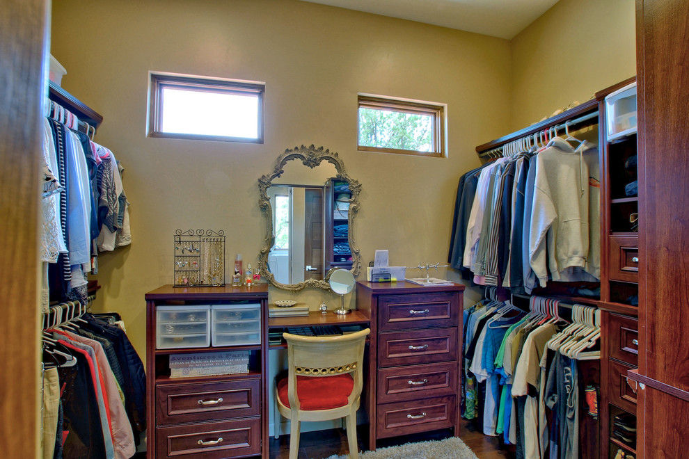 This is an example of an arts and crafts women's walk-in wardrobe in Other with shaker cabinets, dark wood cabinets, dark hardwood floors and brown floor.