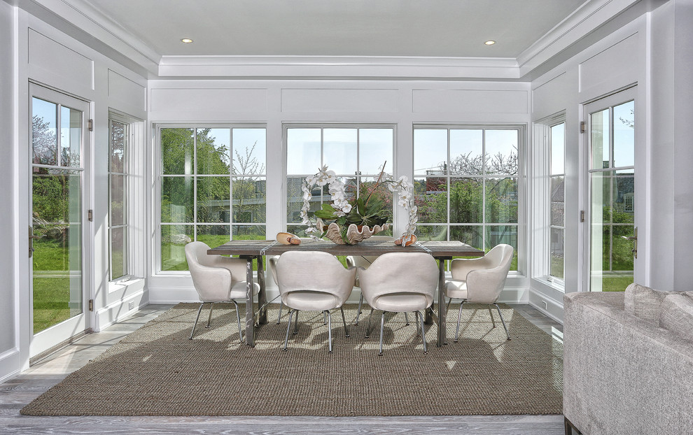 Large beach style open plan dining in New York with white walls, light hardwood floors and grey floor.