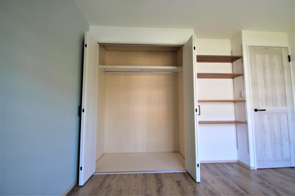 На фото: встроенный шкаф унисекс с плоскими фасадами, светлыми деревянными фасадами, бежевым полом и деревянным потолком