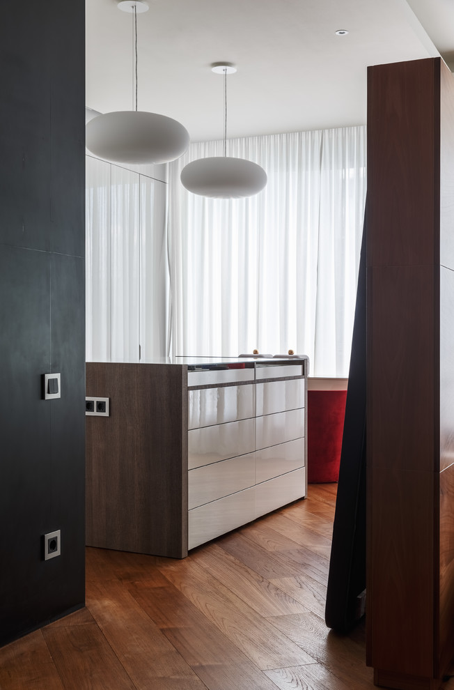 Design ideas for a large contemporary gender-neutral built-in wardrobe in Moscow with flat-panel cabinets, white cabinets, medium hardwood floors and brown floor.