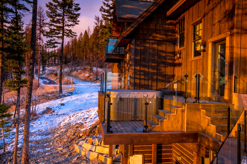 Inspiration for a large rustic backyard deck remodel with a fire pit and no cover