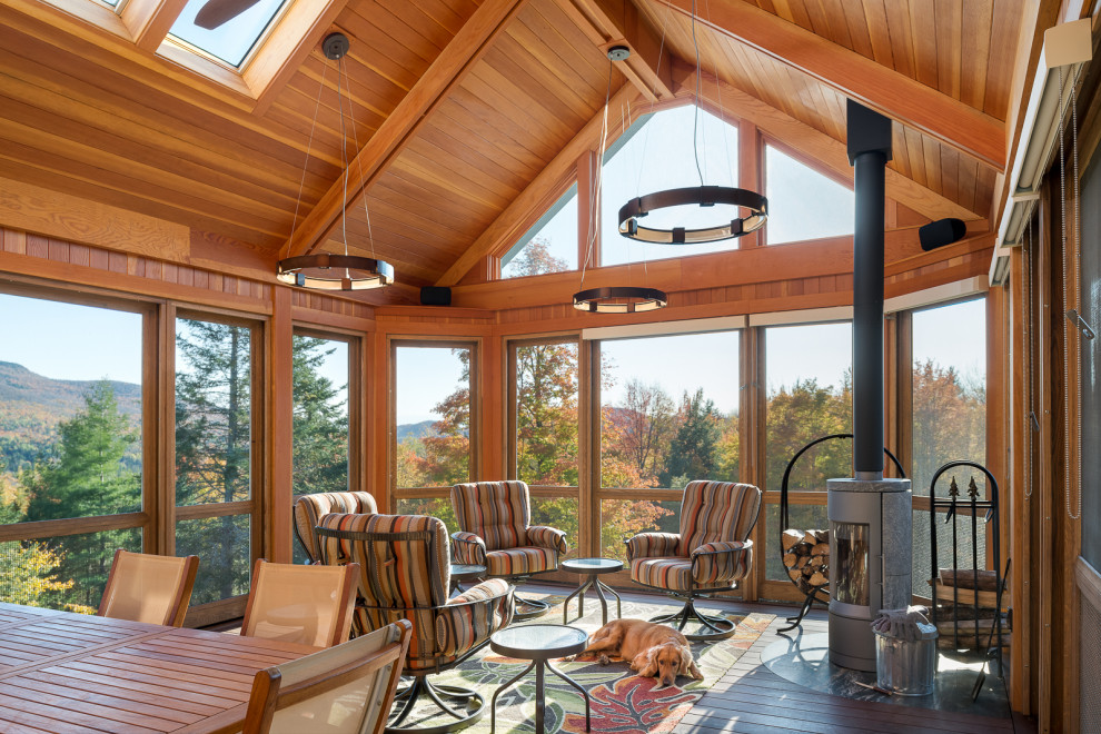 Esempio di una veranda minimal con stufa a legna e soffitto classico
