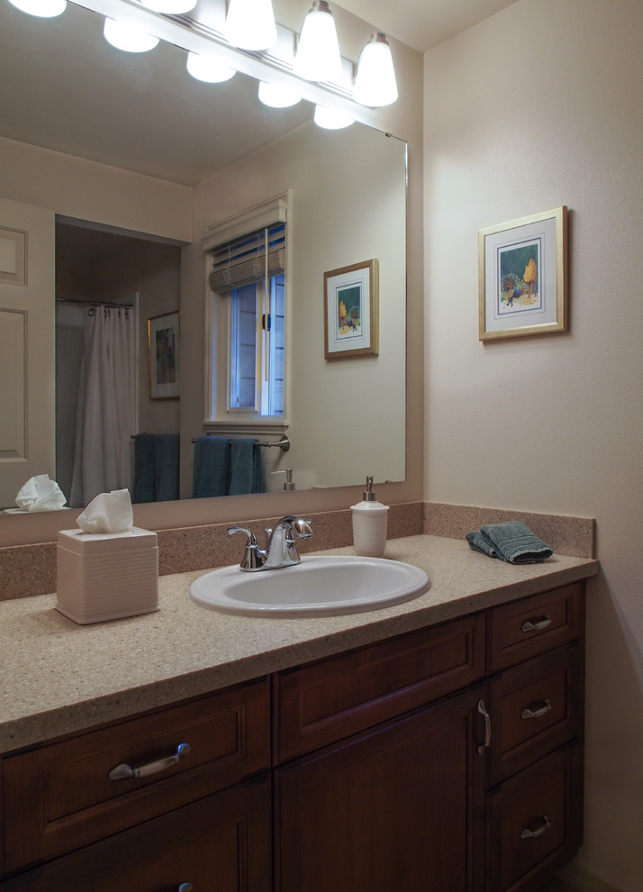 Alcove bathtub - mid-sized transitional 3/4 beige tile linoleum floor, brown floor and single-sink alcove bathtub idea in Seattle with a drop-in sink, recessed-panel cabinets, dark wood cabinets, solid surface countertops, a two-piece toilet, white walls, beige countertops and a built-in vanity