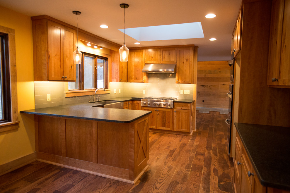 Kitchen pantry - large rustic u-shaped dark wood floor kitchen pantry idea with a single-bowl sink, raised-panel cabinets, medium tone wood cabinets, blue backsplash, ceramic backsplash, stainless steel appliances and no island