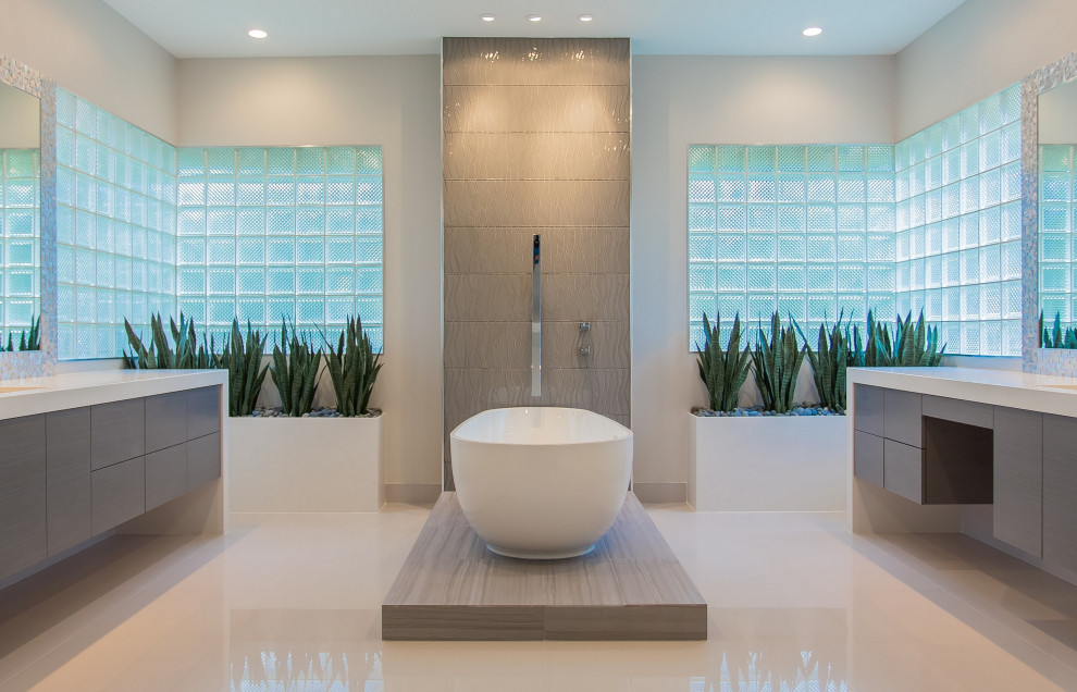 Design ideas for a mid-sized contemporary master bathroom in Chicago with flat-panel cabinets, grey cabinets, a freestanding tub, a two-piece toilet, gray tile, white tile, mosaic tile, white walls, porcelain floors, an undermount sink, engineered quartz benchtops, white floor and white benchtops.