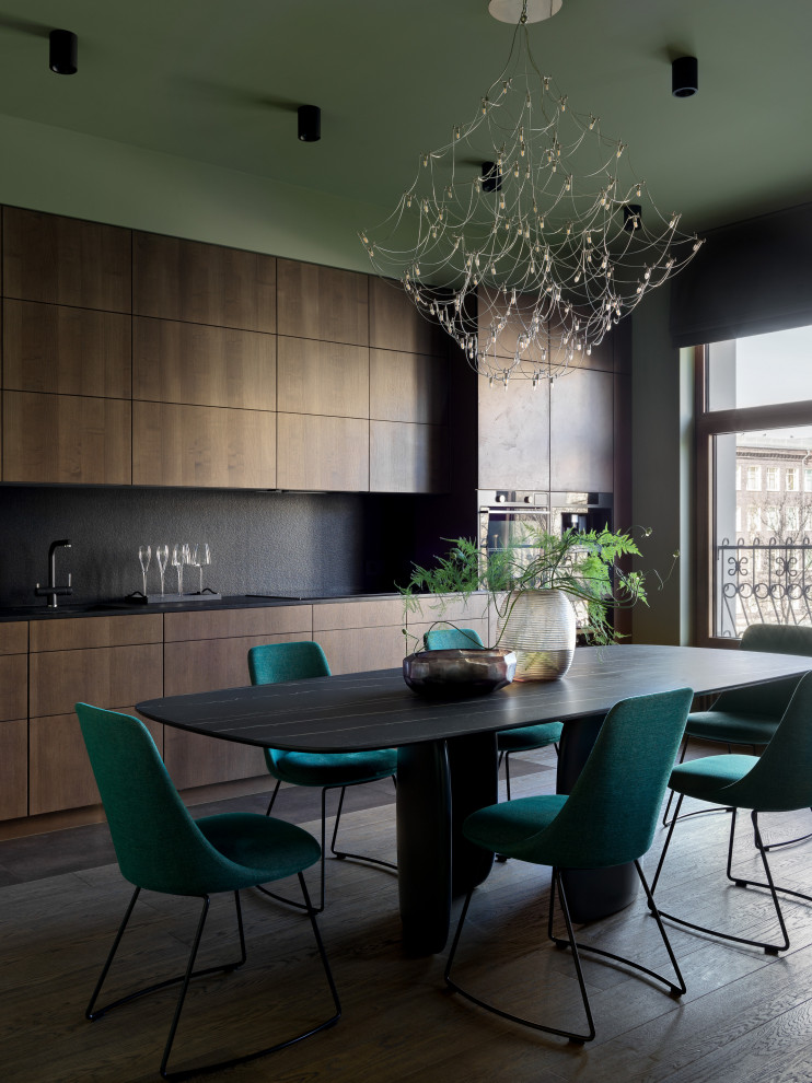 Cette photo montre une grande salle à manger ouverte sur la cuisine tendance avec un mur vert, parquet foncé et un sol marron.