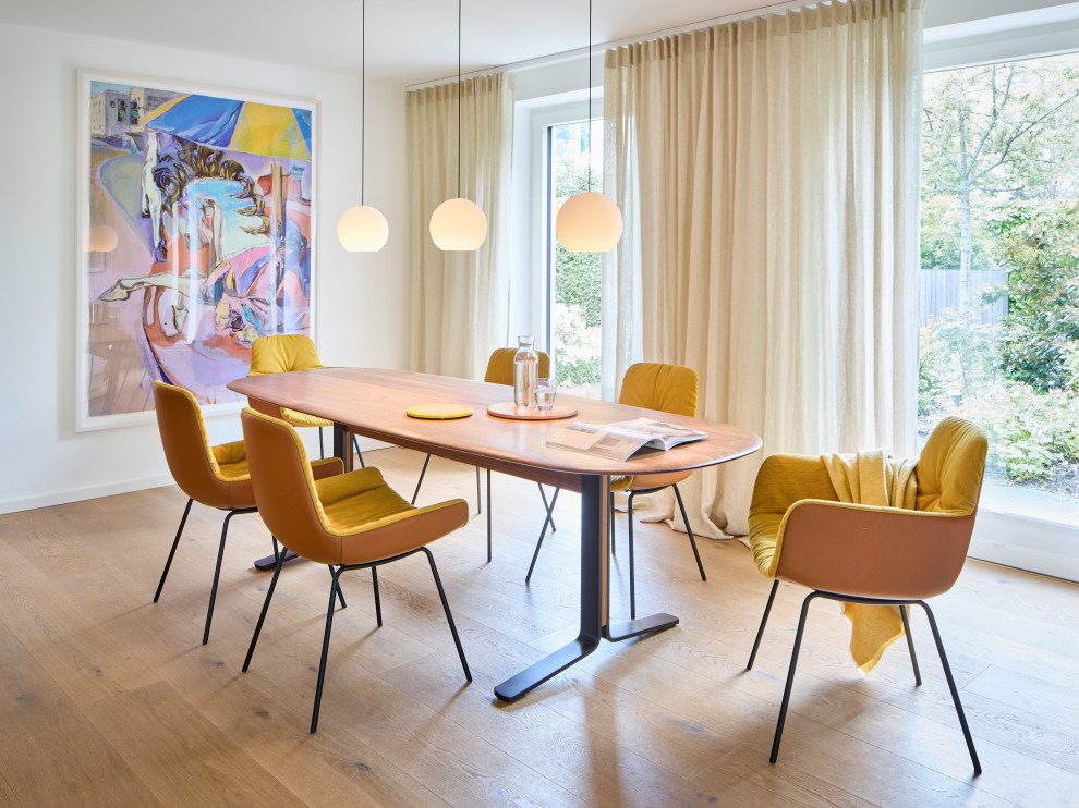 Mid-Century Esszimmer mit hellem Holzboden, weißer Wandfarbe und beigem Boden in München