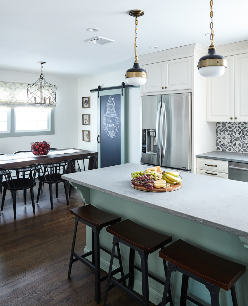 This is an example of a mid-sized country l-shaped eat-in kitchen in New York with raised-panel cabinets, white cabinets, quartz benchtops, multi-coloured splashback, cement tile splashback, stainless steel appliances, with island and grey benchtop.