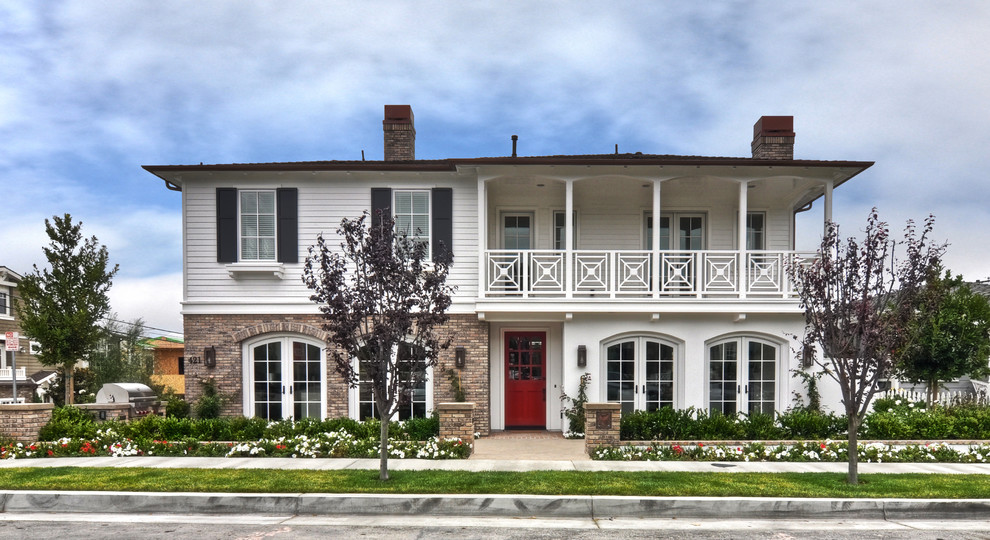 Design ideas for a traditional two-storey white exterior in Orange County with mixed siding.