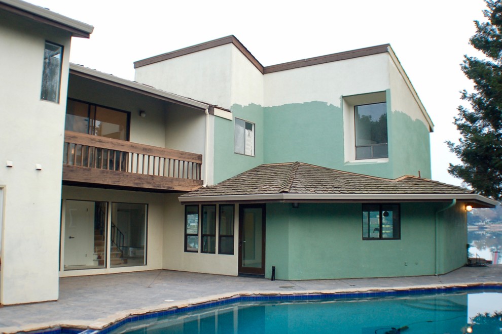 Example of a large trendy beige two-story mixed siding house exterior design with a hip roof