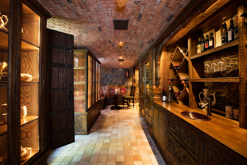 Design ideas for an expansive country wine cellar in Other with terra-cotta floors and display racks.