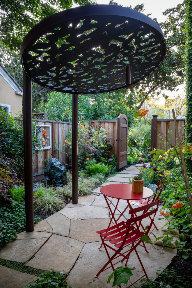 Design ideas for a mediterranean side pergola in San Francisco with natural stone paving and a metal fence.
