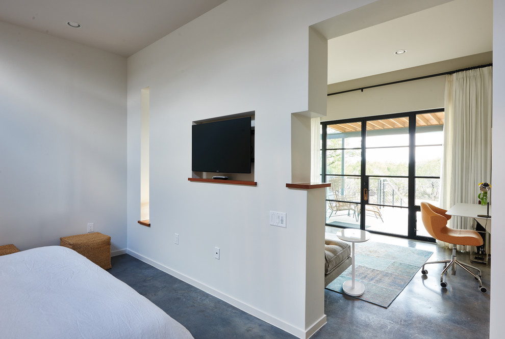 This is an example of a mid-sized modern master bedroom in Austin with white walls, concrete floors, no fireplace and grey floor.