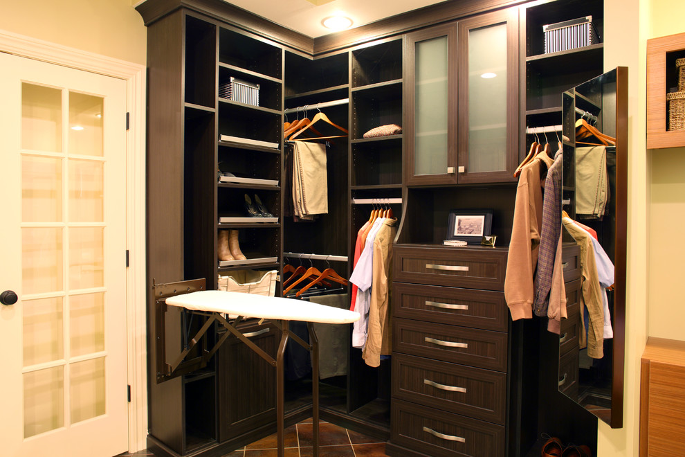 This is an example of a small contemporary walk-in wardrobe in New York with recessed-panel cabinets, dark wood cabinets and porcelain floors.