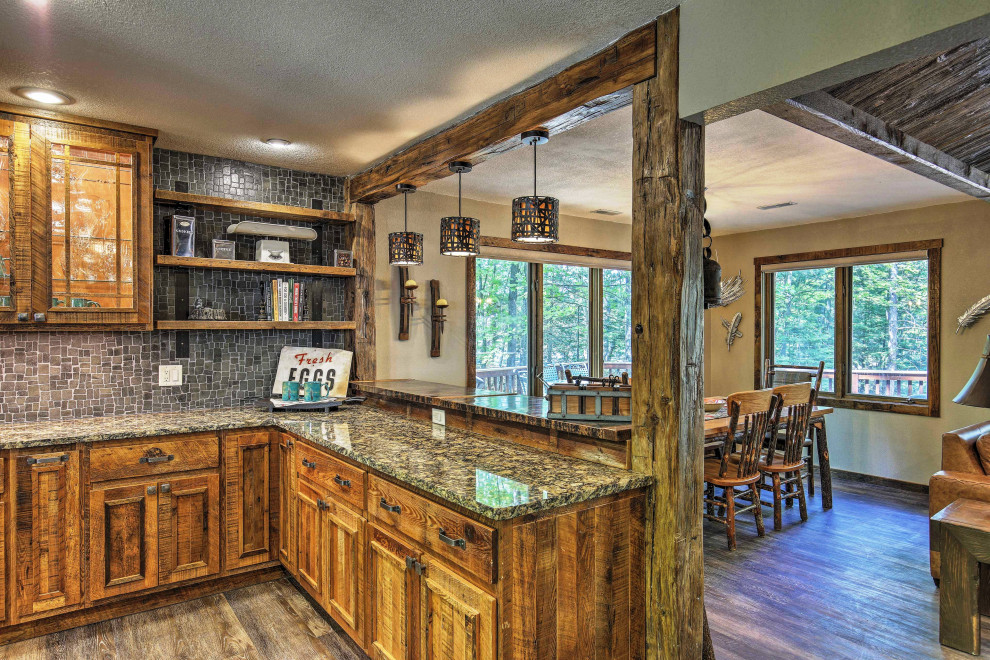 Mid-sized mountain style u-shaped vinyl floor and brown floor eat-in kitchen photo with a farmhouse sink, raised-panel cabinets, distressed cabinets, granite countertops, gray backsplash, stone tile backsplash, stainless steel appliances, an island and multicolored countertops