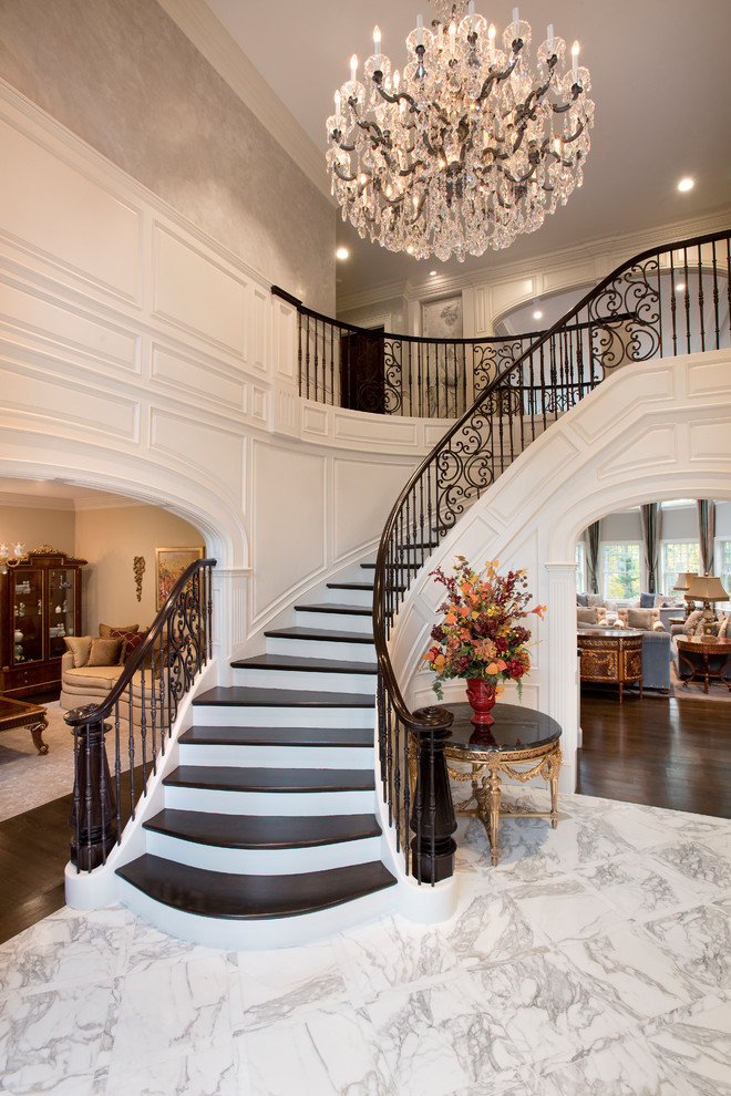 This is an example of a traditional wood curved staircase in Boston with painted wood risers and mixed railing.