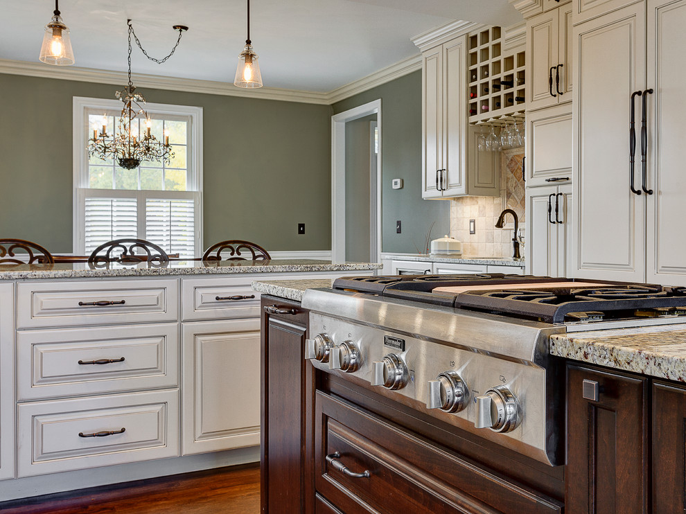Example of a mountain style enclosed kitchen design in Columbus with a farmhouse sink, flat-panel cabinets, white cabinets, marble countertops, beige backsplash, stone tile backsplash and stainless steel appliances