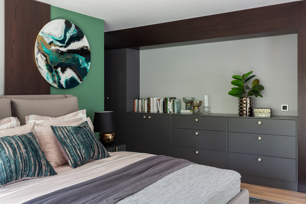 Стильный дизайн: спальня в современном стиле с зелеными стенами, паркетным полом среднего тона и коричневым полом - последний тренд