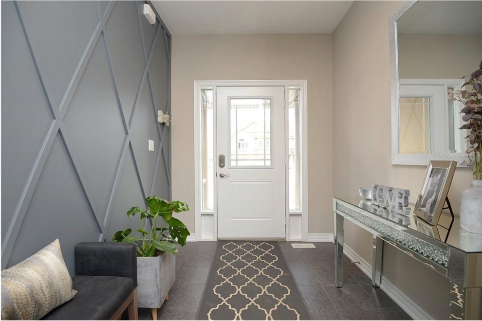 Mid-sized transitional foyer in Toronto with multi-coloured walls, ceramic floors, a single front door, a white front door, grey floor and panelled walls.