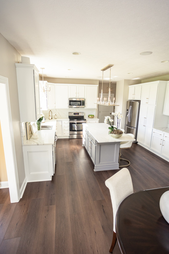 Eat-in kitchen - large traditional l-shaped vinyl floor and brown floor eat-in kitchen idea in Columbus with a drop-in sink, shaker cabinets, white cabinets, granite countertops, white backsplash, granite backsplash, stainless steel appliances, an island and white countertops