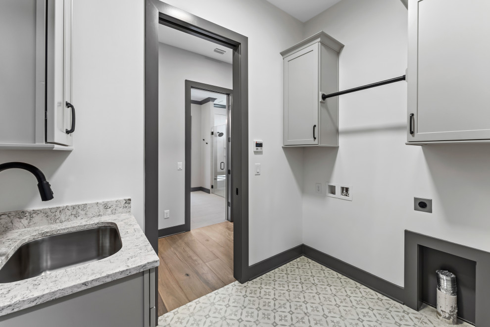 Dedicated laundry room - mid-sized transitional galley dedicated laundry room idea with an undermount sink, recessed-panel cabinets, gray cabinets, a side-by-side washer/dryer and gray countertops