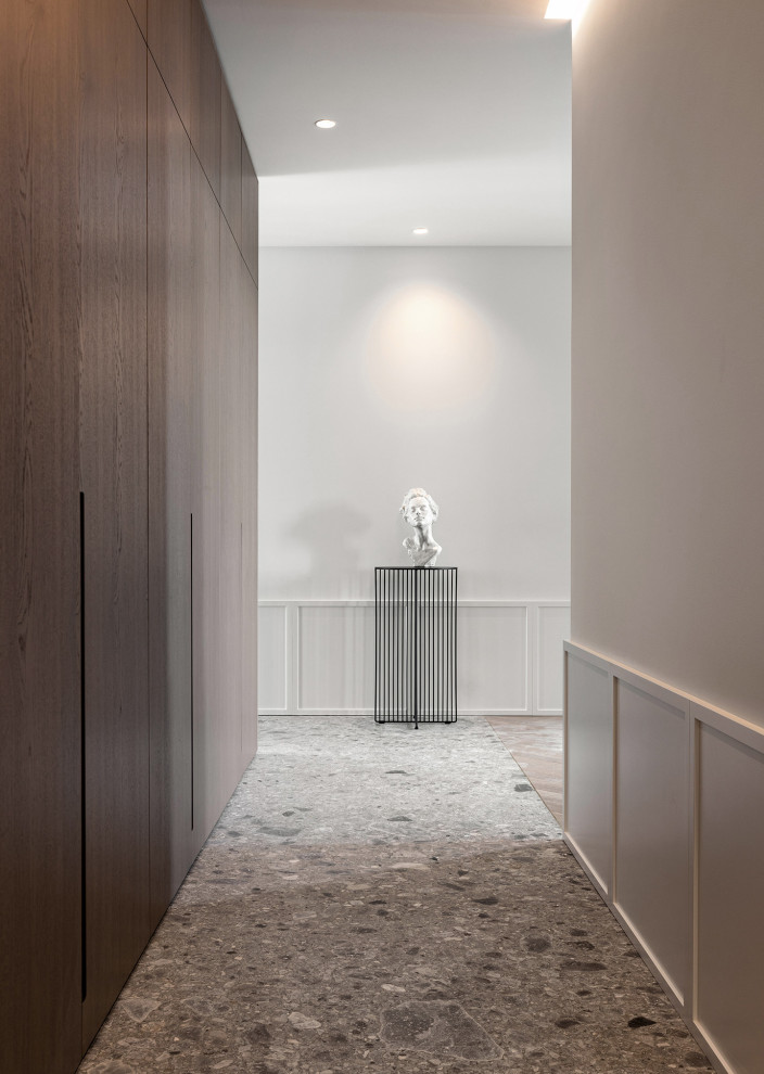 Réalisation d'un couloir design de taille moyenne avec un mur blanc, un sol en marbre, un sol gris et du lambris.