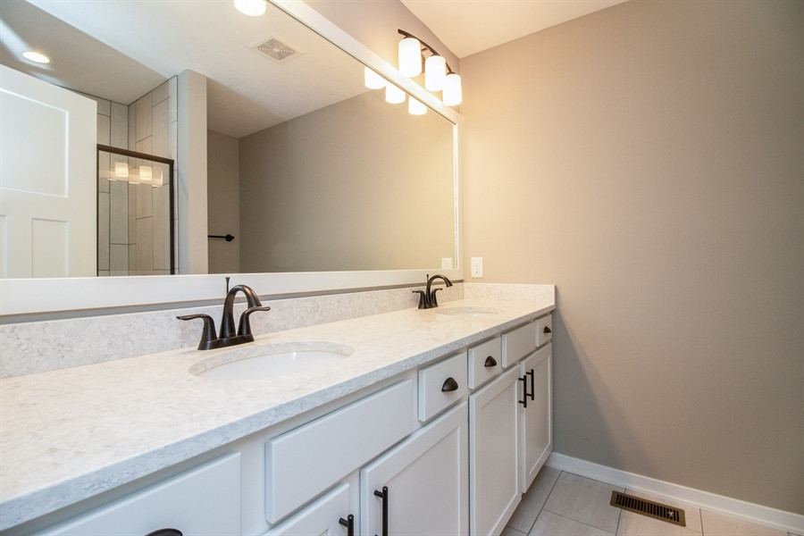 This is an example of a large modern master bathroom in Other with shaker cabinets, white cabinets, an alcove shower, a two-piece toilet, grey walls, ceramic floors, an undermount sink, engineered quartz benchtops, grey floor, a hinged shower door, white benchtops, a double vanity and a built-in vanity.