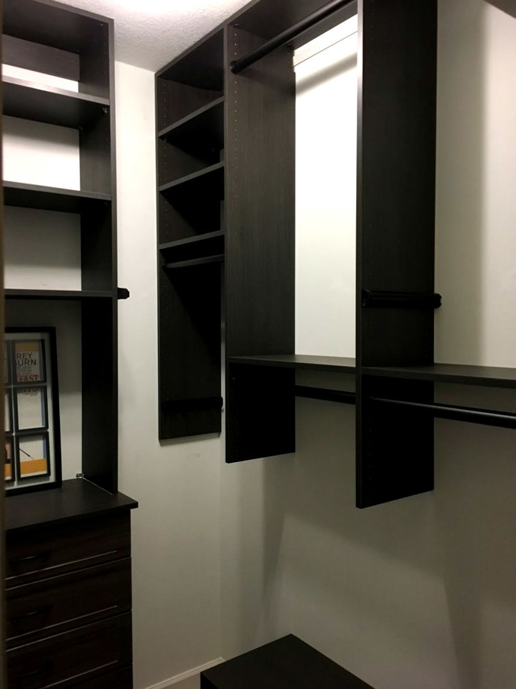 Photo of a mid-sized modern gender-neutral walk-in wardrobe in Other with shaker cabinets and dark wood cabinets.