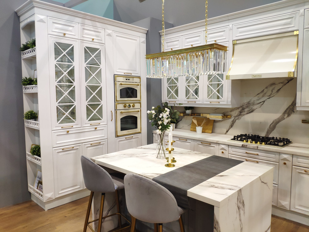 Inspiration för stora klassiska flerfärgat kök, med en undermonterad diskho, luckor med profilerade fronter, vita skåp, marmorbänkskiva, flerfärgad stänkskydd, stänkskydd i marmor, vita vitvaror, laminatgolv, en köksö och brunt golv