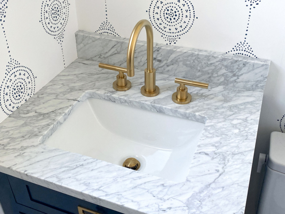 Small transitional powder room in Boston with shaker cabinets, blue cabinets, a two-piece toilet, marble floors, an undermount sink, marble benchtops, grey floor, grey benchtops, a built-in vanity and wallpaper.