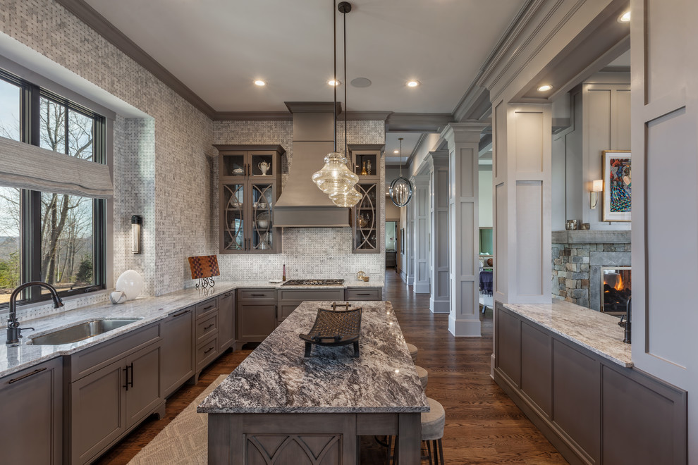 Transitional l-shaped dark wood floor and brown floor kitchen photo with an undermount sink, recessed-panel cabinets, gray cabinets, multicolored backsplash, mosaic tile backsplash and an island