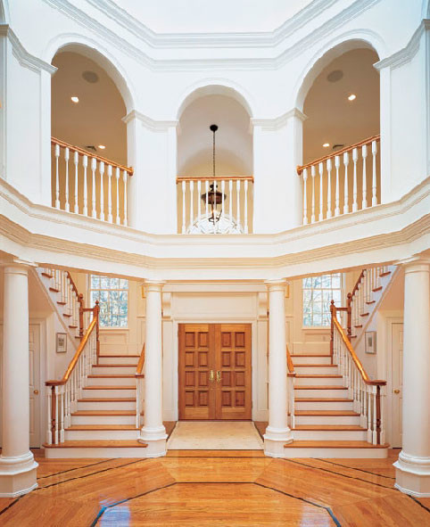 Example of a large transitional light wood floor foyer design in Boston with white walls and a light wood front door