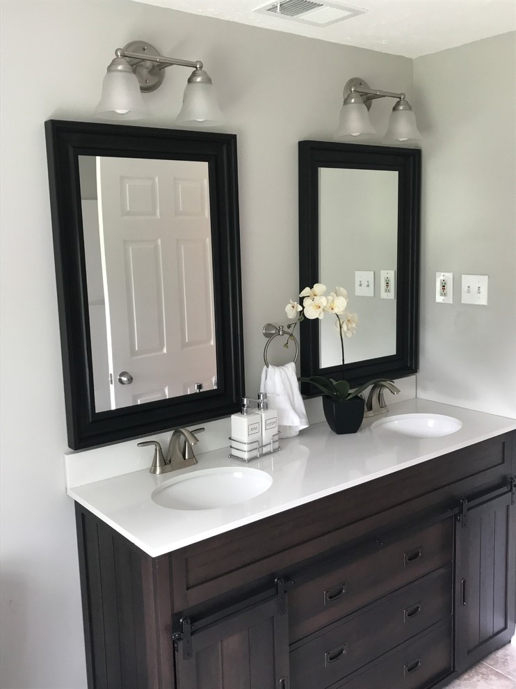 Inspiration for a mid-sized traditional 3/4 bathroom in Other with shaker cabinets, dark wood cabinets, grey walls, ceramic floors, an undermount sink, solid surface benchtops and brown floor.