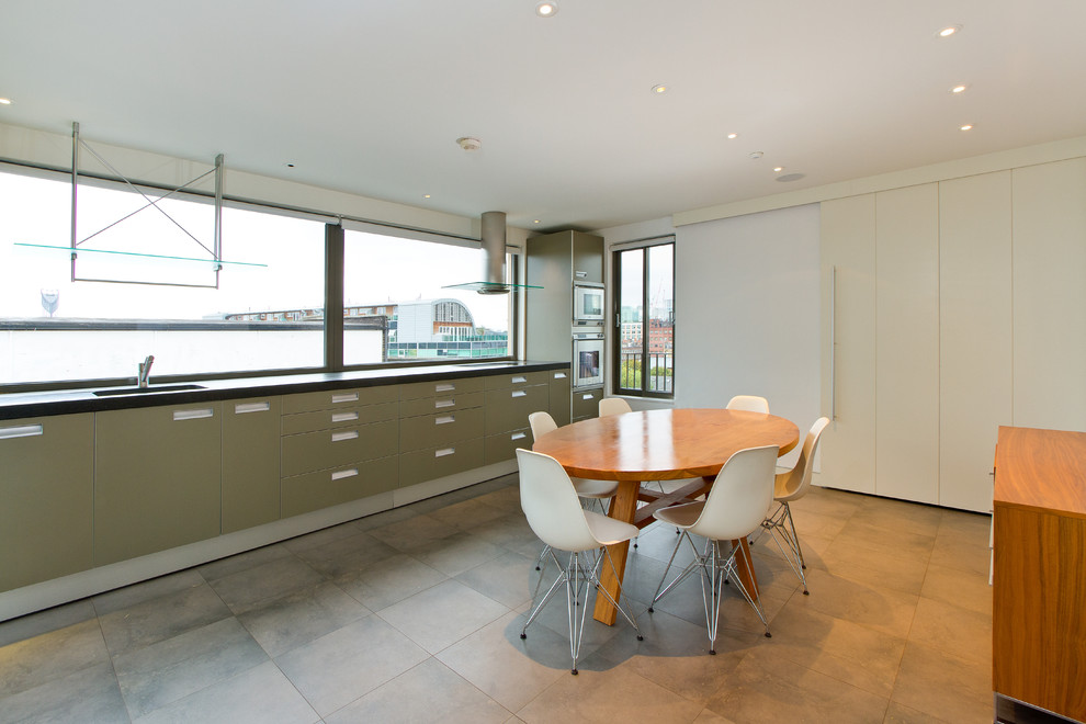Inspiration for a contemporary eat-in kitchen in London with flat-panel cabinets and beige cabinets.