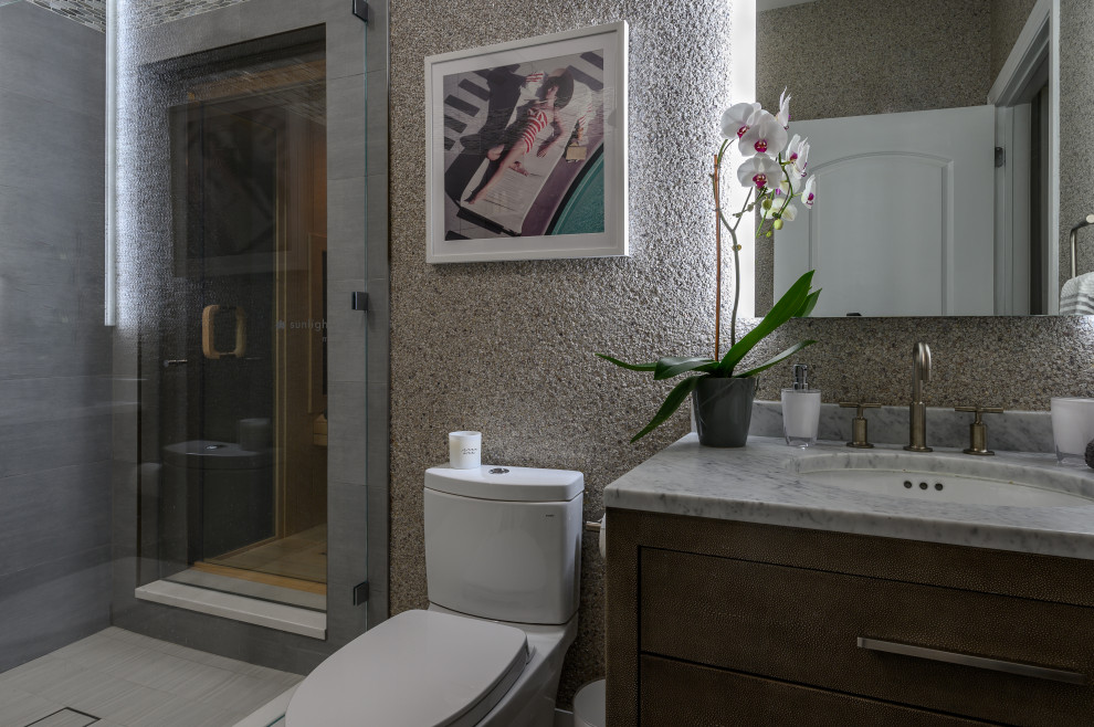 Mid-sized transitional 3/4 bathroom in New York with flat-panel cabinets, dark wood cabinets, an open shower, a one-piece toilet, white walls, porcelain floors, an undermount sink, marble benchtops, grey floor, grey benchtops, a single vanity, a freestanding vanity and wallpaper.