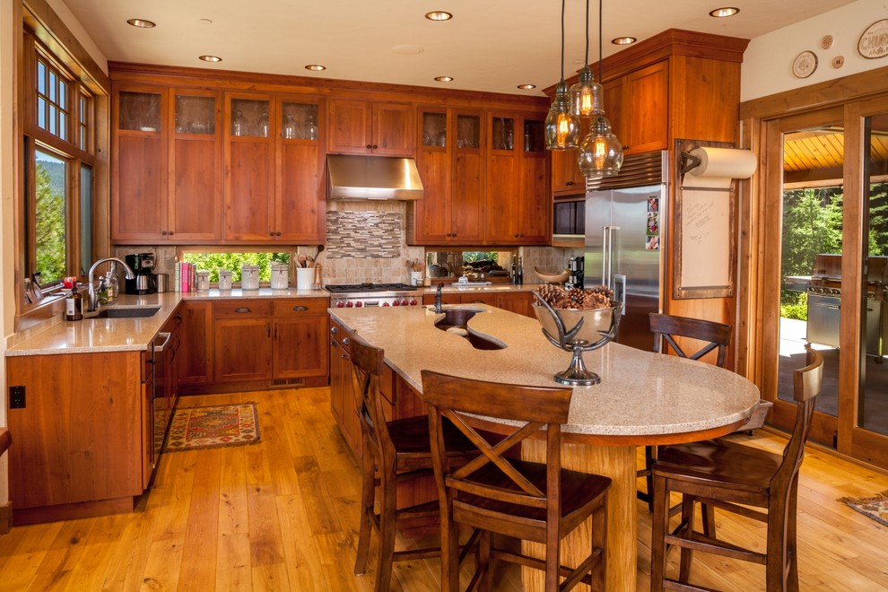 Example of a large mountain style u-shaped light wood floor and brown floor open concept kitchen design in Seattle with medium tone wood cabinets, beige backsplash, stainless steel appliances and an island