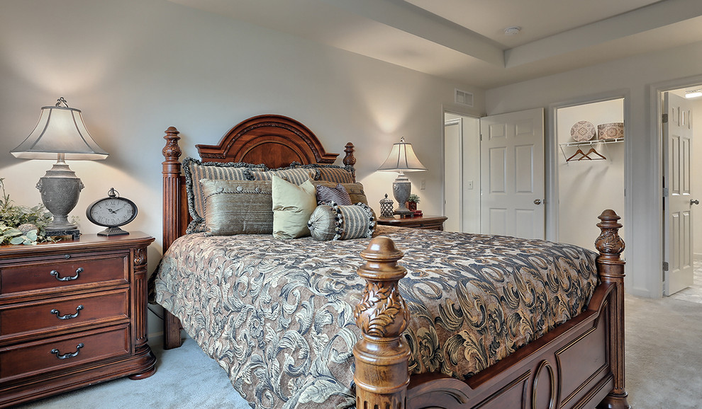This is an example of a large traditional master bedroom in Other with beige walls and carpet.