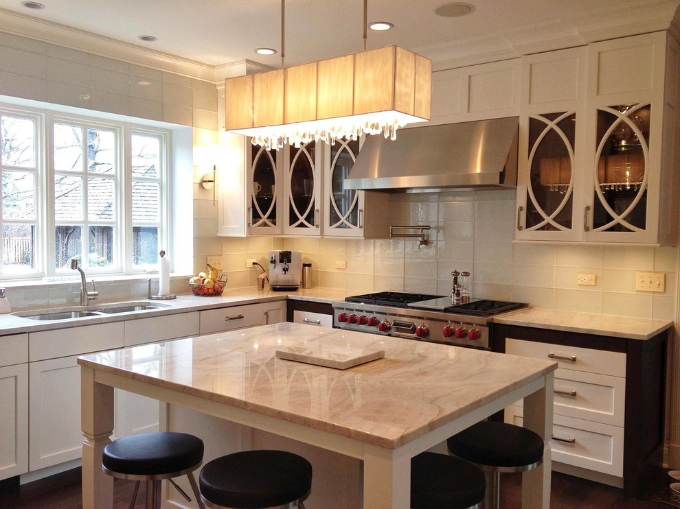 Mid-sized transitional u-shaped dark wood floor and brown floor enclosed kitchen photo in Chicago with a double-bowl sink, shaker cabinets, white cabinets, marble countertops, white backsplash, ceramic backsplash, stainless steel appliances and an island