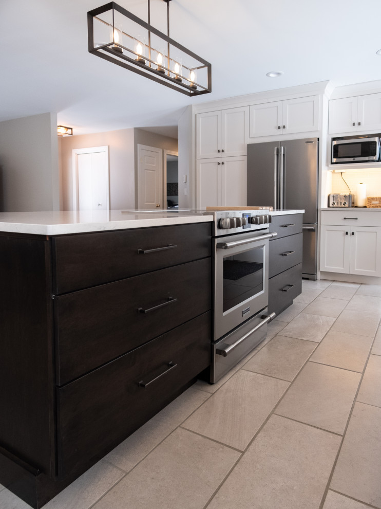 Example of a transitional l-shaped porcelain tile and white floor eat-in kitchen design with an undermount sink, shaker cabinets, white cabinets, quartz countertops, white backsplash, subway tile backsplash, stainless steel appliances, an island and white countertops