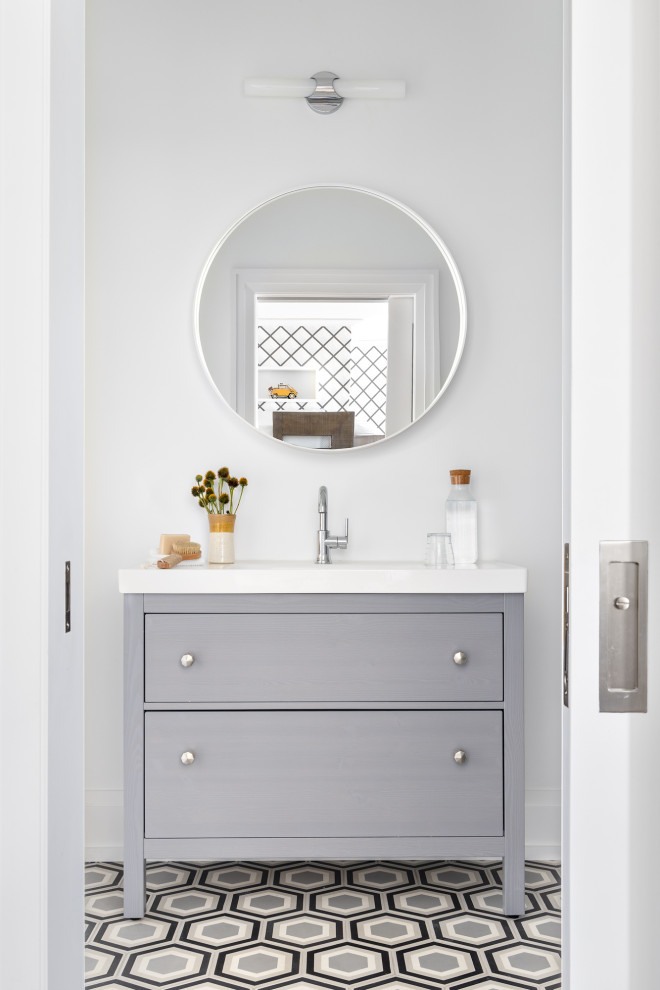 This is an example of an expansive beach style kids bathroom in Other with flat-panel cabinets, grey cabinets, a shower/bathtub combo, a one-piece toilet, white walls, cement tiles, an integrated sink, grey floor, a shower curtain, white benchtops, a single vanity and a freestanding vanity.