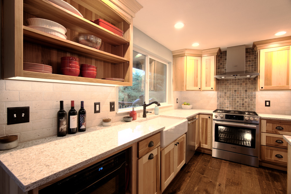 Mid-sized mountain style l-shaped medium tone wood floor eat-in kitchen photo in Seattle with a farmhouse sink, shaker cabinets, light wood cabinets, quartz countertops, beige backsplash, stone tile backsplash, stainless steel appliances and an island