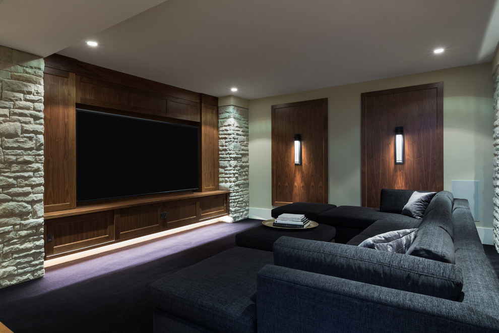 Photo of a large contemporary enclosed home theatre in Vancouver with beige walls, medium hardwood floors, a built-in media wall and blue floor.