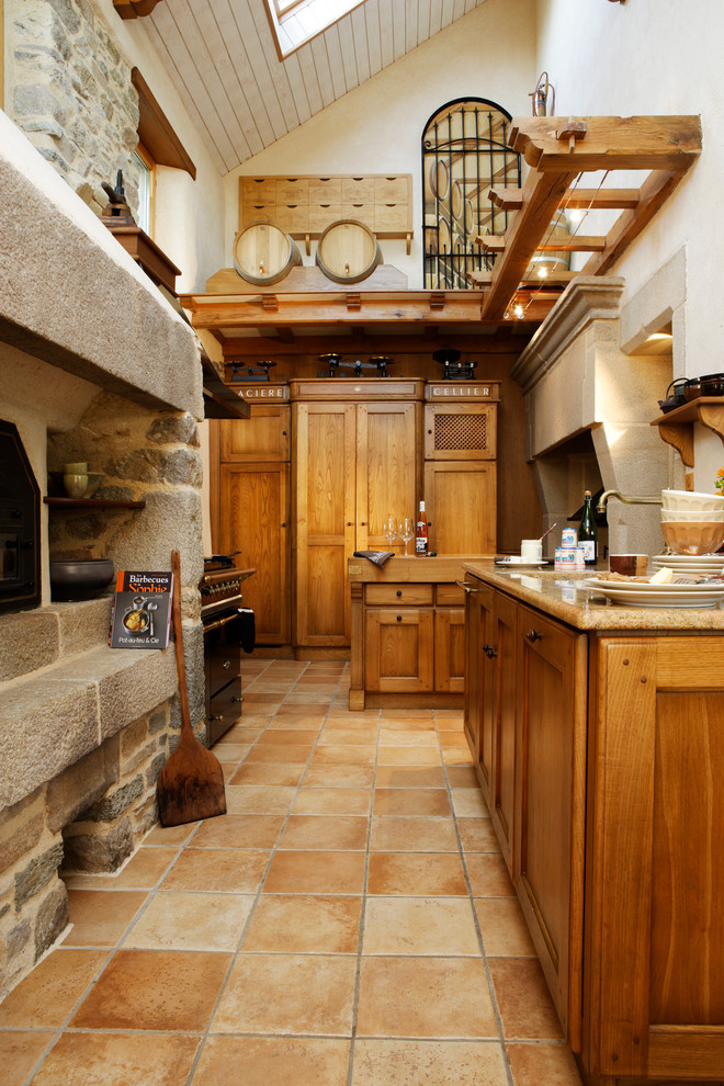 This is an example of a country l-shaped separate kitchen in Rennes with beaded inset cabinets, light wood cabinets and no island.