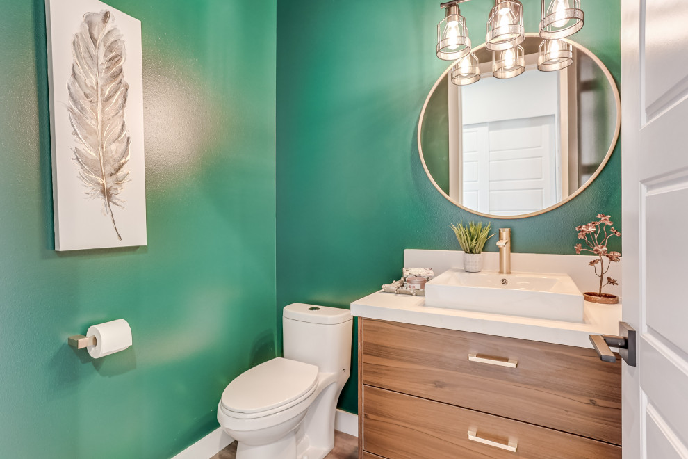 Photo of a contemporary powder room in Seattle with flat-panel cabinets, medium wood cabinets, green walls, a vessel sink, brown floor and white benchtops.
