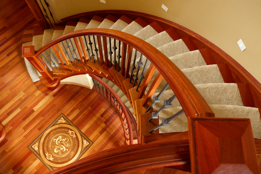 Photo of a traditional carpeted curved staircase in Edmonton with carpet risers.
