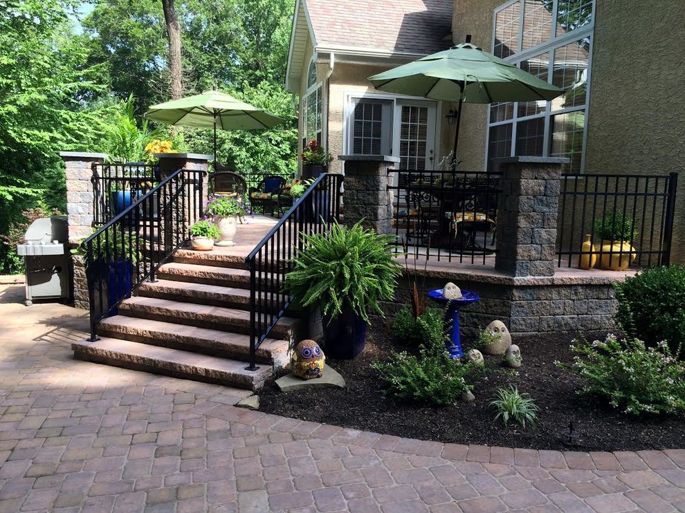 Design ideas for a mid-sized traditional backyard patio in Wilmington with natural stone pavers and no cover.