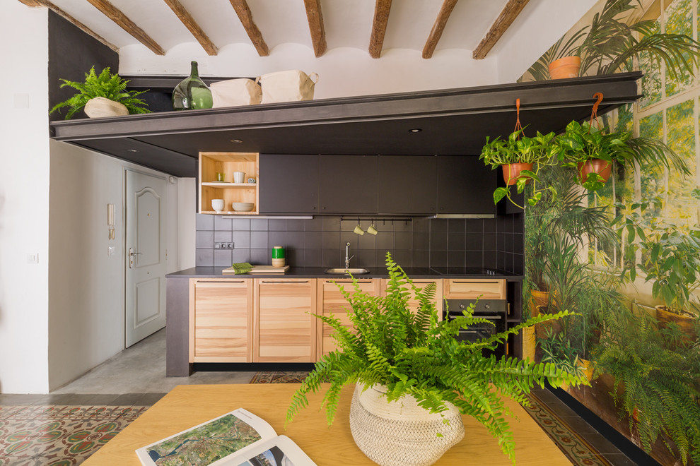 Mid-sized tropical single-wall eat-in kitchen in Barcelona with flat-panel cabinets, medium wood cabinets, black splashback, no island, ceramic splashback and stainless steel appliances.