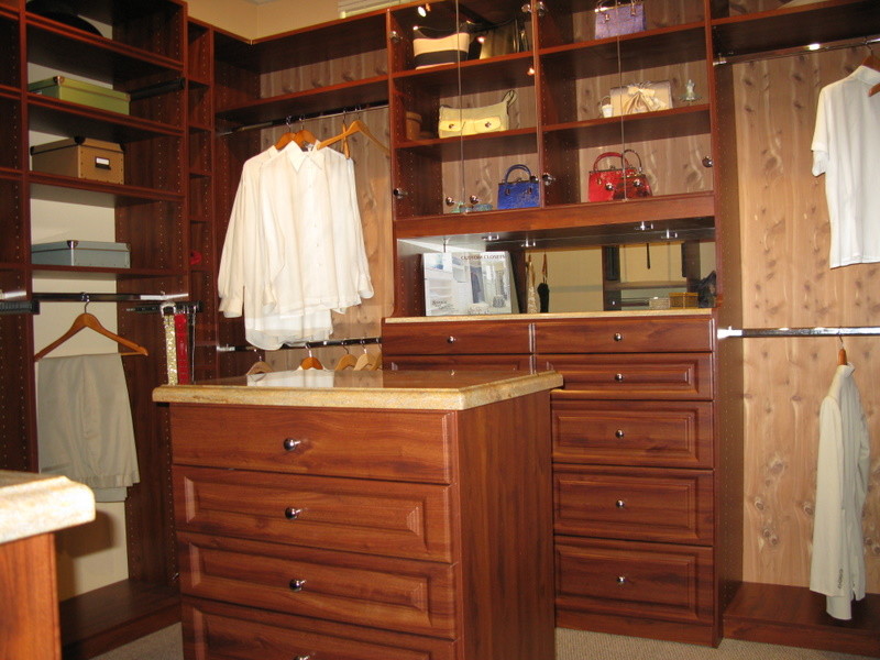 Inspiration for a large walk-in wardrobe in Sacramento with raised-panel cabinets, dark wood cabinets and carpet.