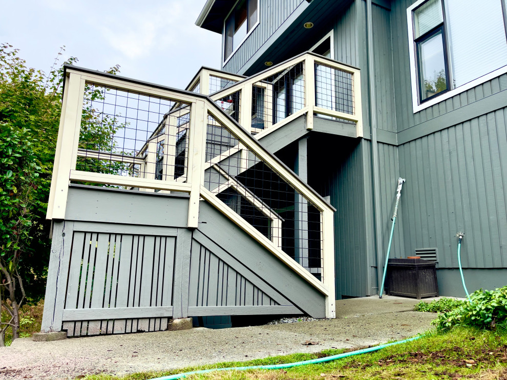 Deck - large modern backyard mixed material railing deck idea in Seattle