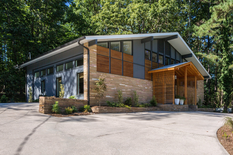 This is an example of a midcentury two-storey blue exterior in Raleigh with mixed siding and a gable roof.